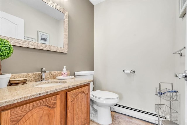 bathroom featuring vanity, baseboard heating, and toilet