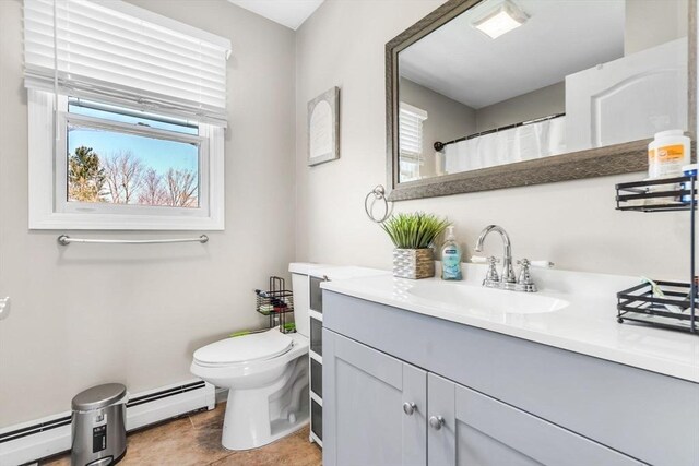 full bath with vanity, a baseboard radiator, a wealth of natural light, and toilet