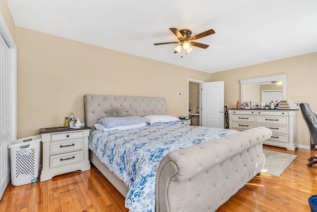 bedroom featuring light wood-style floors, a ceiling fan, baseboards, and a closet