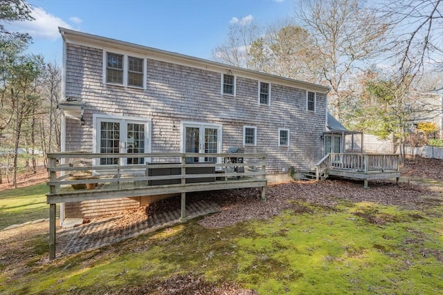 back of property featuring a wooden deck, a lawn, and french doors