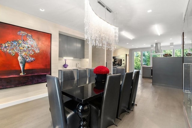 dining space with light hardwood / wood-style floors and a chandelier