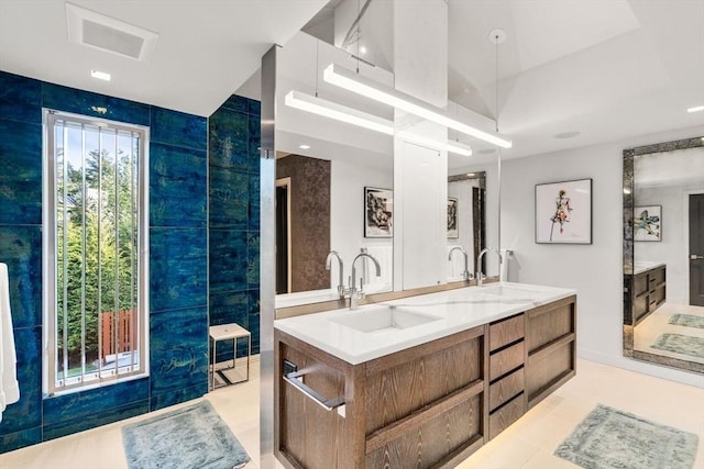 bathroom with tile walls, tile patterned flooring, and vanity