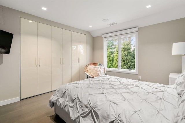 bedroom with light wood-type flooring and vaulted ceiling