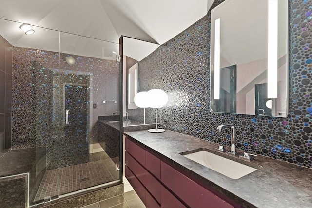 bathroom featuring vaulted ceiling, tile walls, tile patterned floors, backsplash, and vanity