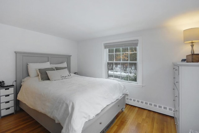 bedroom with wood-type flooring and baseboard heating