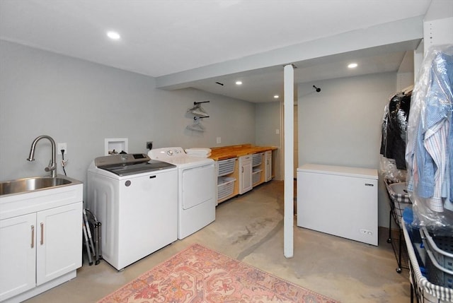 laundry room with laundry area, washing machine and dryer, a sink, and recessed lighting