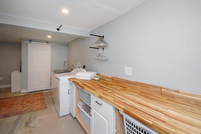 washroom with washer and dryer, a sink, recessed lighting, and a barn door