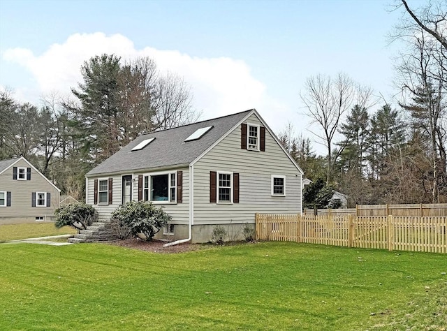 back of house featuring a shingled roof, fence, and a yard