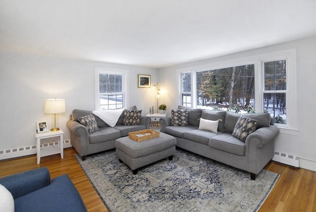 living room with baseboard heating, wood finished floors, and baseboards