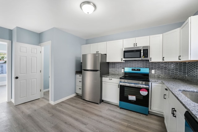 kitchen featuring stainless steel appliances, light hardwood / wood-style flooring, and white cabinets