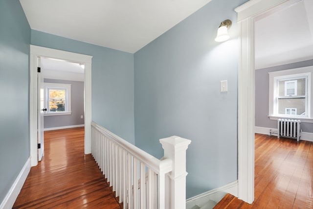 hallway with radiator and dark hardwood / wood-style flooring