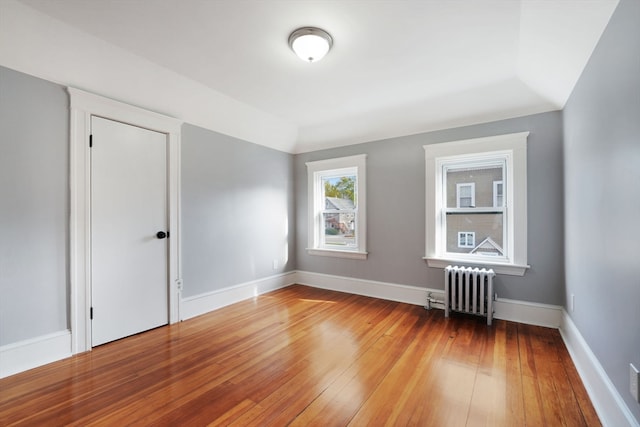 additional living space featuring radiator, wood-type flooring, and lofted ceiling