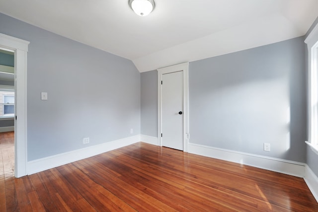 empty room with lofted ceiling and hardwood / wood-style floors