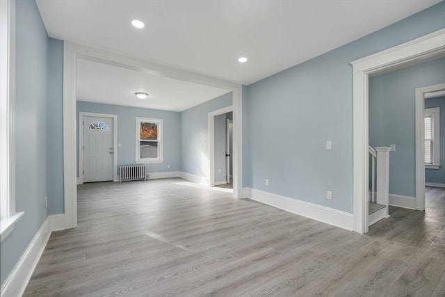 unfurnished living room featuring light wood-type flooring and radiator