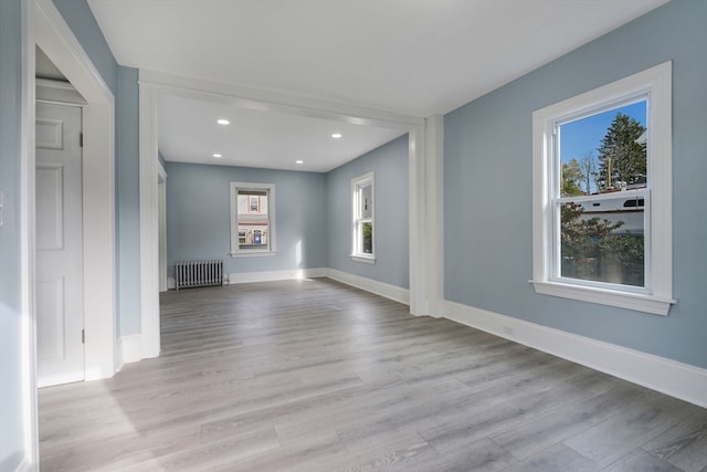 unfurnished living room with light hardwood / wood-style floors and radiator