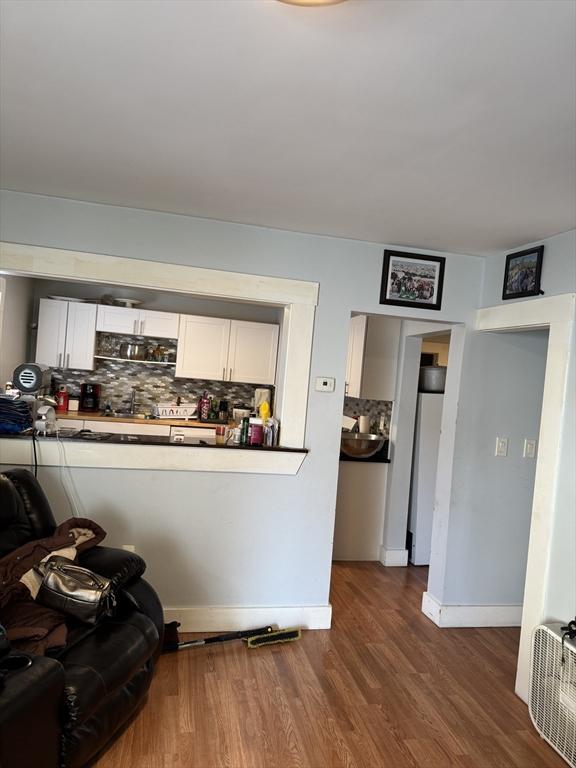 interior space with white cabinetry, dark hardwood / wood-style floors, and decorative backsplash
