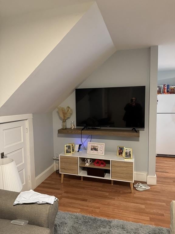 living room with hardwood / wood-style flooring and vaulted ceiling
