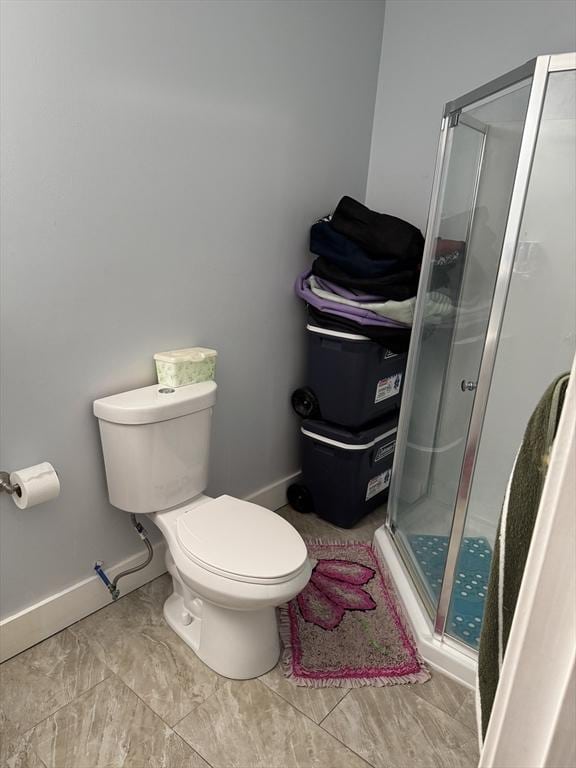 bathroom with a shower with shower door and toilet