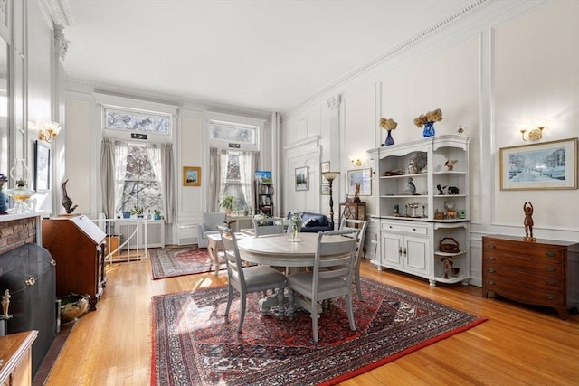 dining space featuring crown molding and light hardwood / wood-style flooring