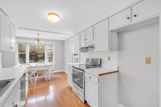 kitchen with under cabinet range hood, appliances with stainless steel finishes, white cabinets, and light countertops