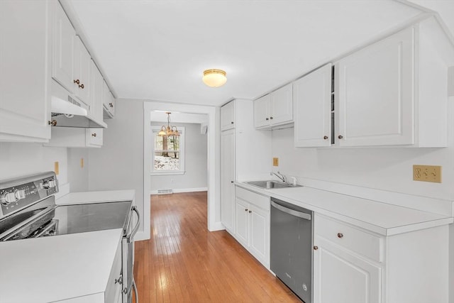 kitchen with under cabinet range hood, white cabinets, appliances with stainless steel finishes, and a sink