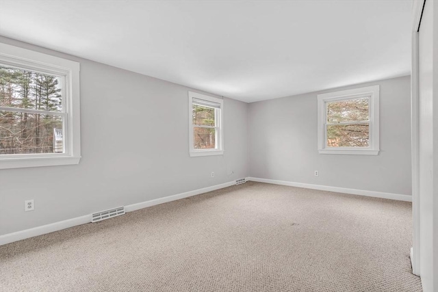 unfurnished room featuring visible vents, baseboards, and carpet