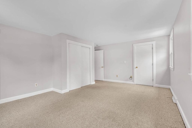 spare room with light colored carpet and baseboards