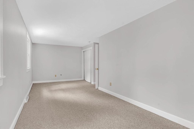 empty room featuring baseboards and carpet floors