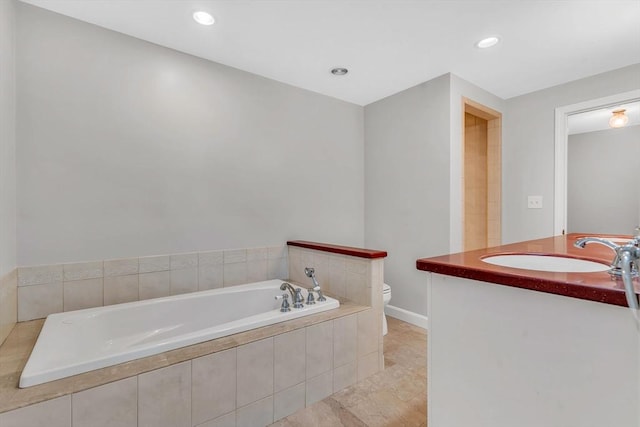 full bathroom featuring toilet, a bath, vanity, and recessed lighting