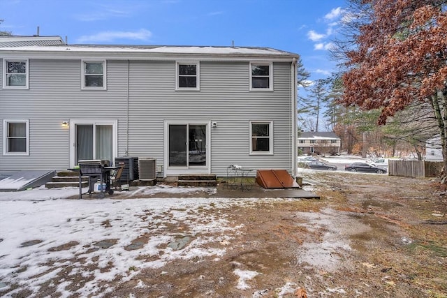 snow covered rear of property with entry steps