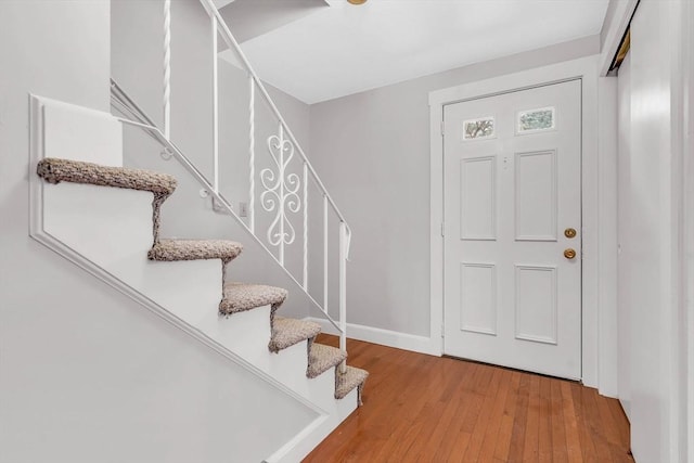 entrance foyer with light wood finished floors, stairs, and baseboards