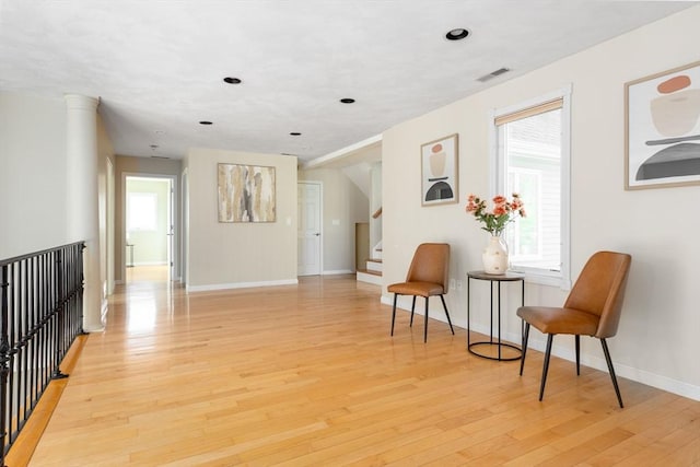 living area with visible vents, baseboards, recessed lighting, light wood-style floors, and stairs