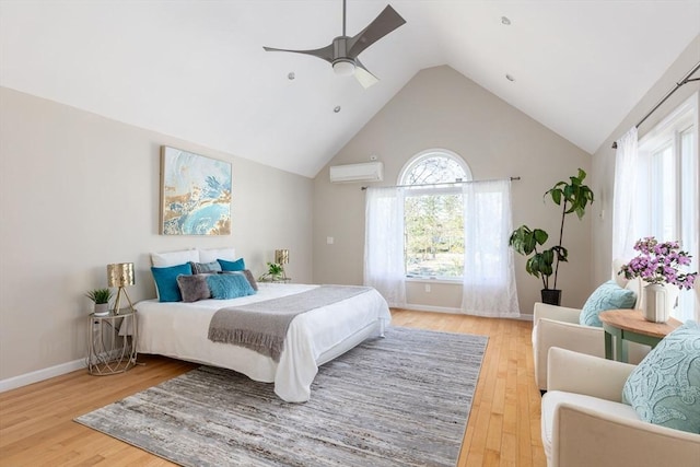 bedroom featuring an AC wall unit, a ceiling fan, light wood finished floors, baseboards, and lofted ceiling