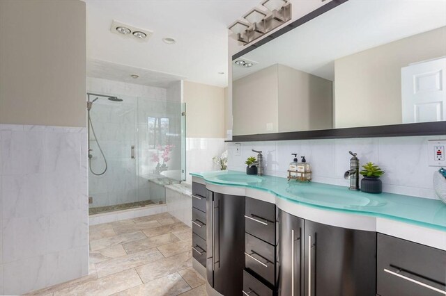 bathroom featuring double vanity, tile patterned floors, a stall shower, and a sink