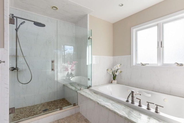 bathroom with a bath, a shower stall, and tile patterned floors