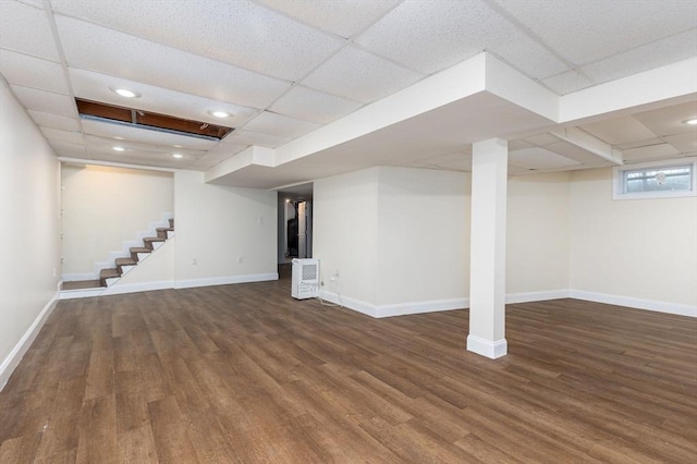 below grade area featuring baseboards, wood finished floors, a drop ceiling, and recessed lighting