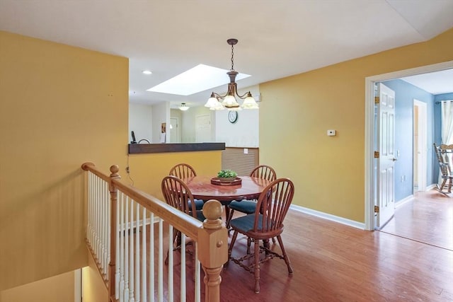 dining room featuring wood finished floors, baseboards, a chandelier, and recessed lighting