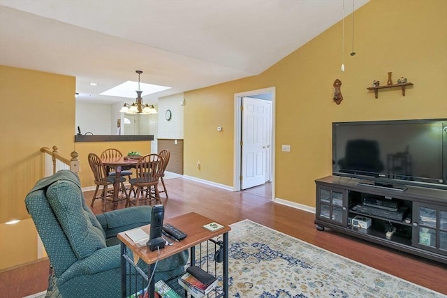 living area featuring wood finished floors, a chandelier, and baseboards