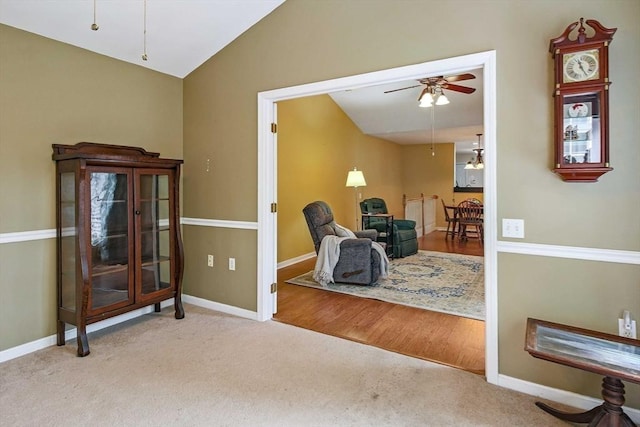 sitting room with a ceiling fan, lofted ceiling, carpet, and baseboards