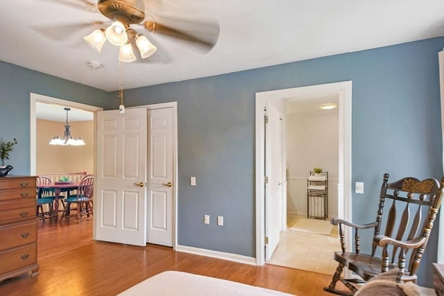 bedroom with light wood-style flooring, a chandelier, and baseboards
