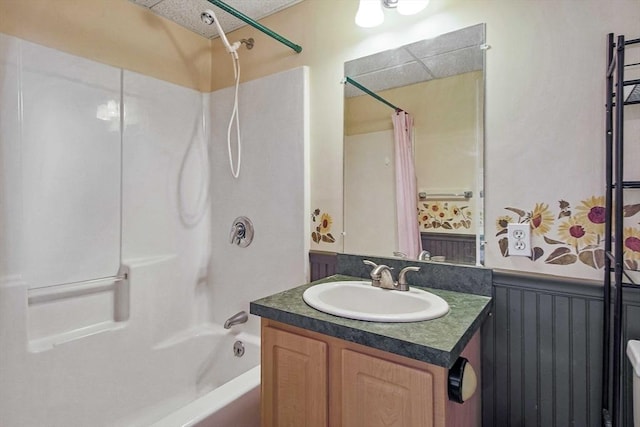 bathroom featuring shower / tub combo, wainscoting, and vanity