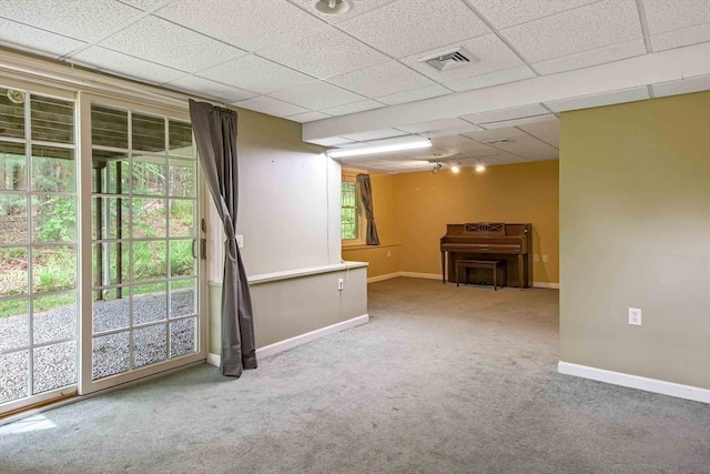 below grade area with carpet floors, baseboards, and a paneled ceiling