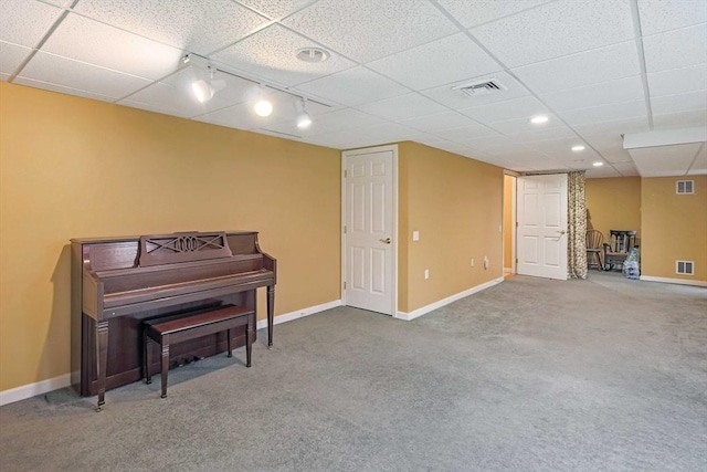 sitting room with carpet floors, track lighting, baseboards, and a drop ceiling