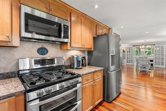 115 Depot, Boxford, MA 01921 - kitchen featuring appliances with stainless steel finishes, light wood-type flooring, backsplash, brown cabinets, and recessed lighting