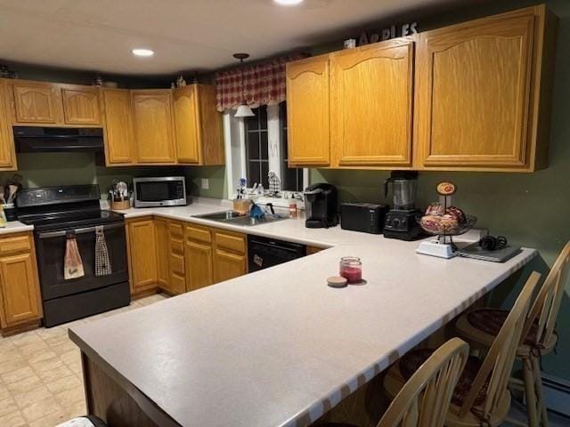 kitchen featuring black appliances, extractor fan, sink, kitchen peninsula, and a breakfast bar