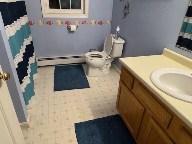 bathroom featuring toilet, vanity, and a baseboard radiator