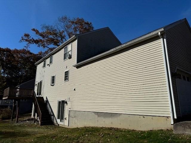 view of home's exterior featuring a garage, a deck, and cooling unit