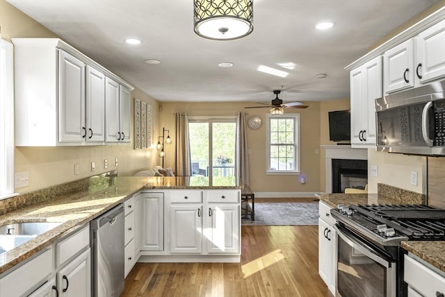 20 Copper Lantern Ln Unit 20, Carver, MA 02330 - kitchen with appliances with stainless steel finishes, a peninsula, light wood-type flooring, a ceiling fan, and white cabinetry