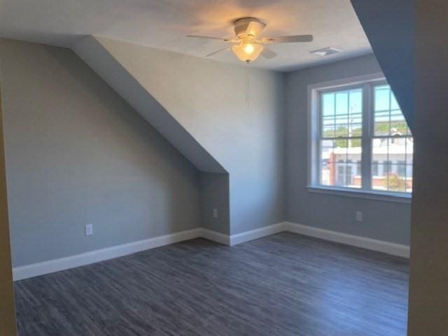 additional living space with lofted ceiling, wood finished floors, baseboards, and ceiling fan