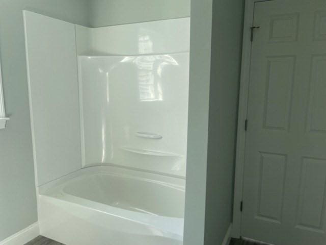 full bath with baseboards and shower / tub combination